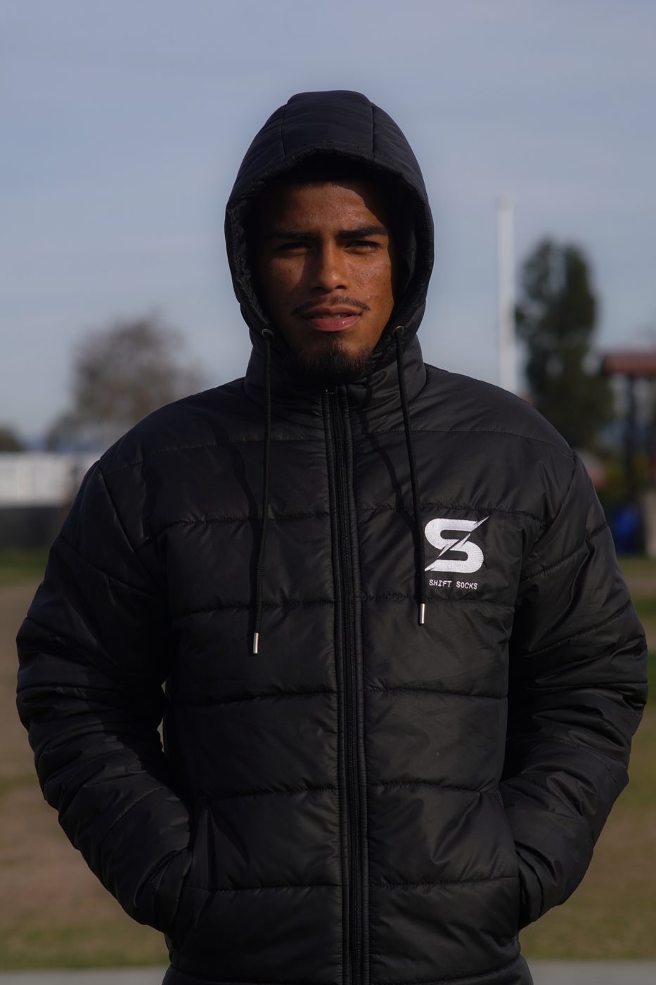 Player in a custom black hooded team jacket