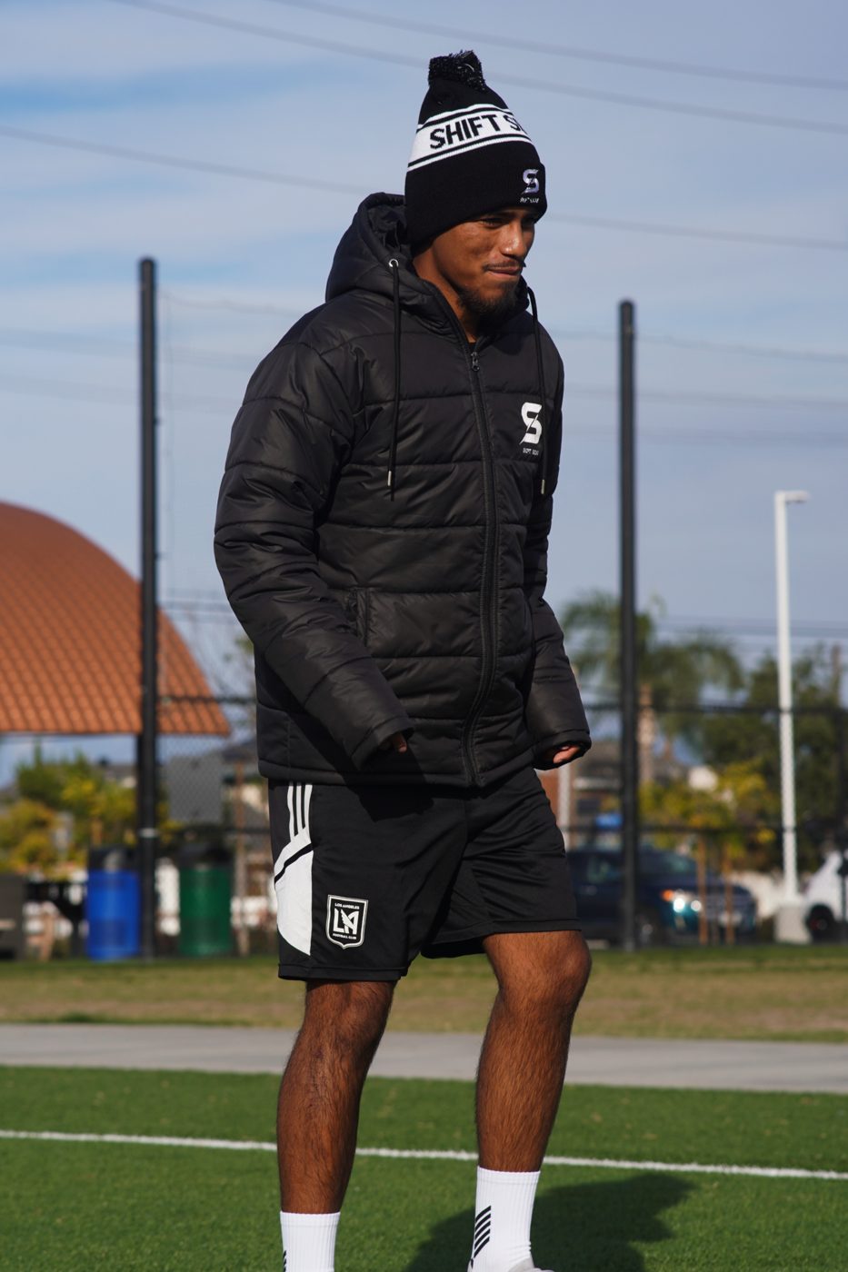 Player in a black team jacket and beanie